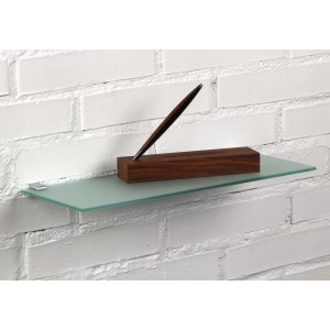 Mensola a muro in vetro con portapenne in legno, montata su parete di mattoni bianchi.