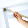 Pennello angolare LUX 50 mm in uso: mano che dipinge l'angolo con pittura a emulsione.