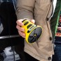 Raschiaghiaccio elettrico Kärcher EDI 4 giallo in mano davanti all'auto. Utile aiuto per l'inverno.