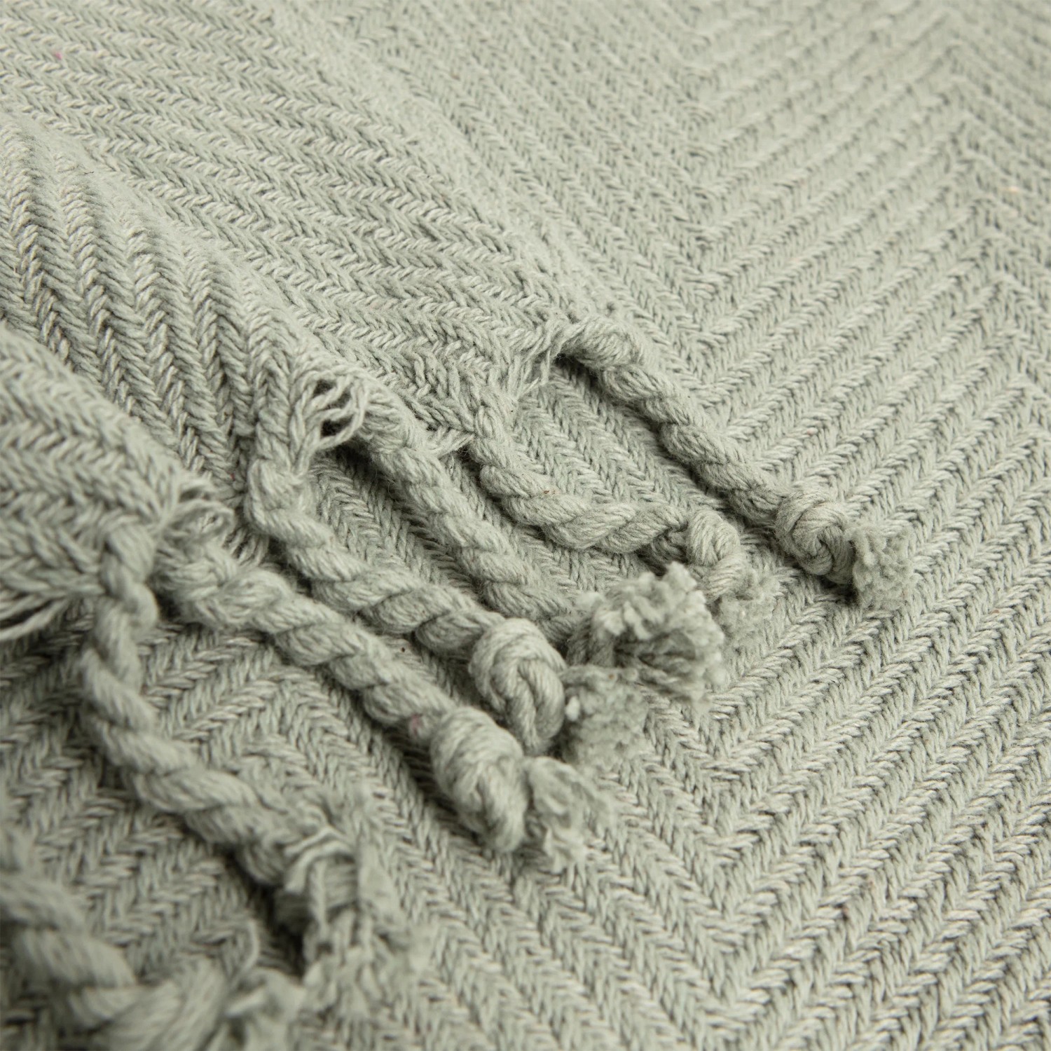 Coperta/plaid t.b.t. grigia con motivo a treccia e frange, dettaglio.