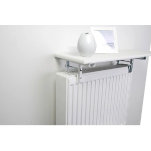 Mensola bianca OBI per radiatore con ripiano sopra il radiatore, decorata con vaso e cornice.