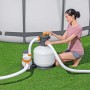 Donna che utilizza filtro a sabbia per piscina. Sistema di filtraggio con piscina in giardino.