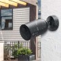 Telecamera di sorveglianza da esterno a batteria Ezviz EB3 nera montata su una parete di casa sotto la pioggia.
