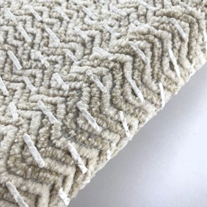 Tappeto da bagno beige con motivo a zigzag e rivestimento antiscivolo.