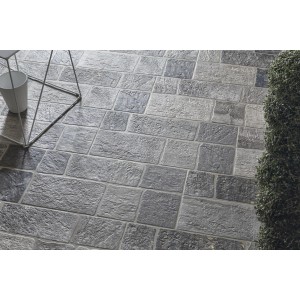 Pavimentazione per esterni grigia, posata a motivo irregolare.