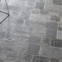 Pavimentazione per esterni grigia, posata a motivo irregolare.