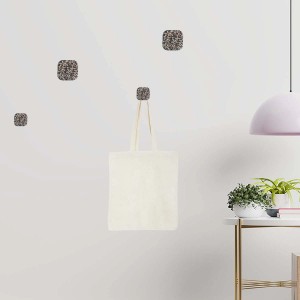 Appendiabiti da parete t.b.t. con ganci quadrati effetto pietra e borsa di stoffa.
