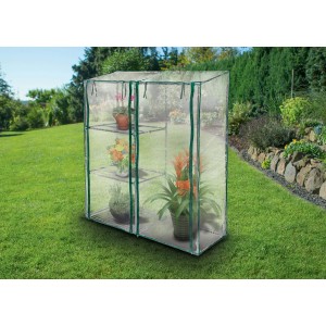 Piccola serra t.b.t. con piante su tre ripiani in giardino.