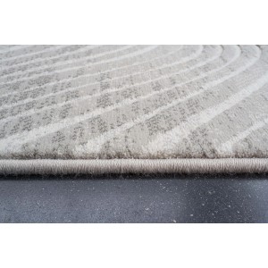 Dettaglio di un tappeto moderno con motivo astratto nei toni del beige e del bianco.