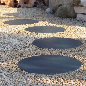 Passo giapponese rotondo in pietra naturale (t.b.t.) su sentiero di ghiaia in giardino.