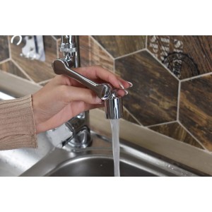 Donna che aziona il rubinetto t.b.t. Rompigetto con acqua che scorre.