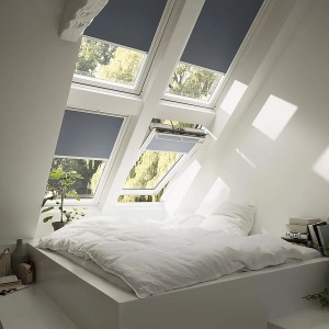 Tenda oscurante Velux DKL MK06 blu scuro in finestre per tetti di una camera da letto.