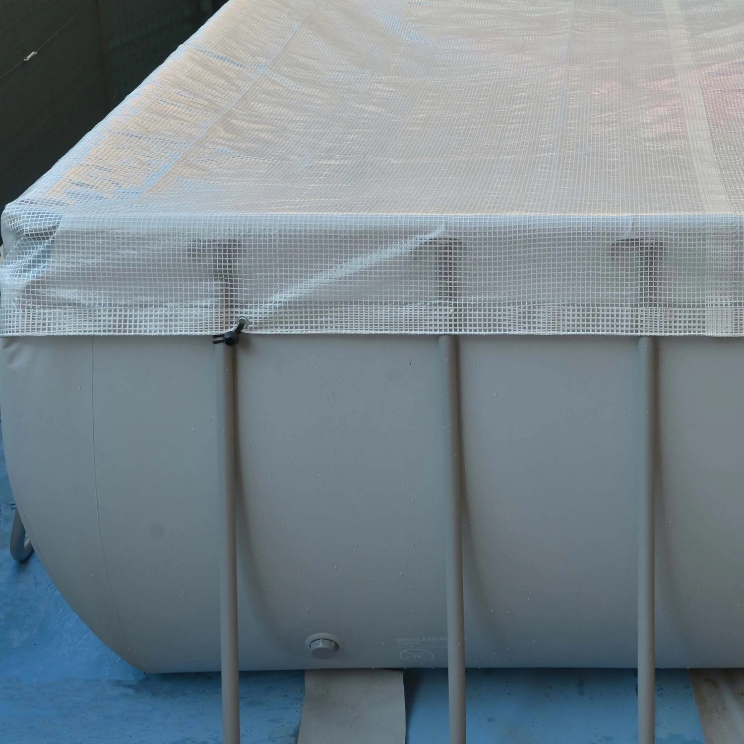 Copertura per piscina, telo protettivo in tessuto chiaro.