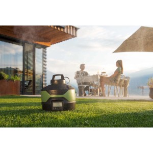 Pistola a spruzzo t.b.t. in uso su prato con persone sedute sullo sfondo.