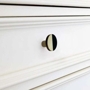 Pomello per mobile t.b.t., rotondo, bicolore (nero/beige) su cassetto bianco.