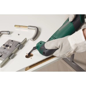 Lama per sega a immersione LUX in uso: il multiutensile sega un foro nella porta per il raccordo della porta. Accessori per seghe.