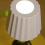 Luce decorativa da esterni t.b.t. a forma di cono, posizionata su una bottiglia.
