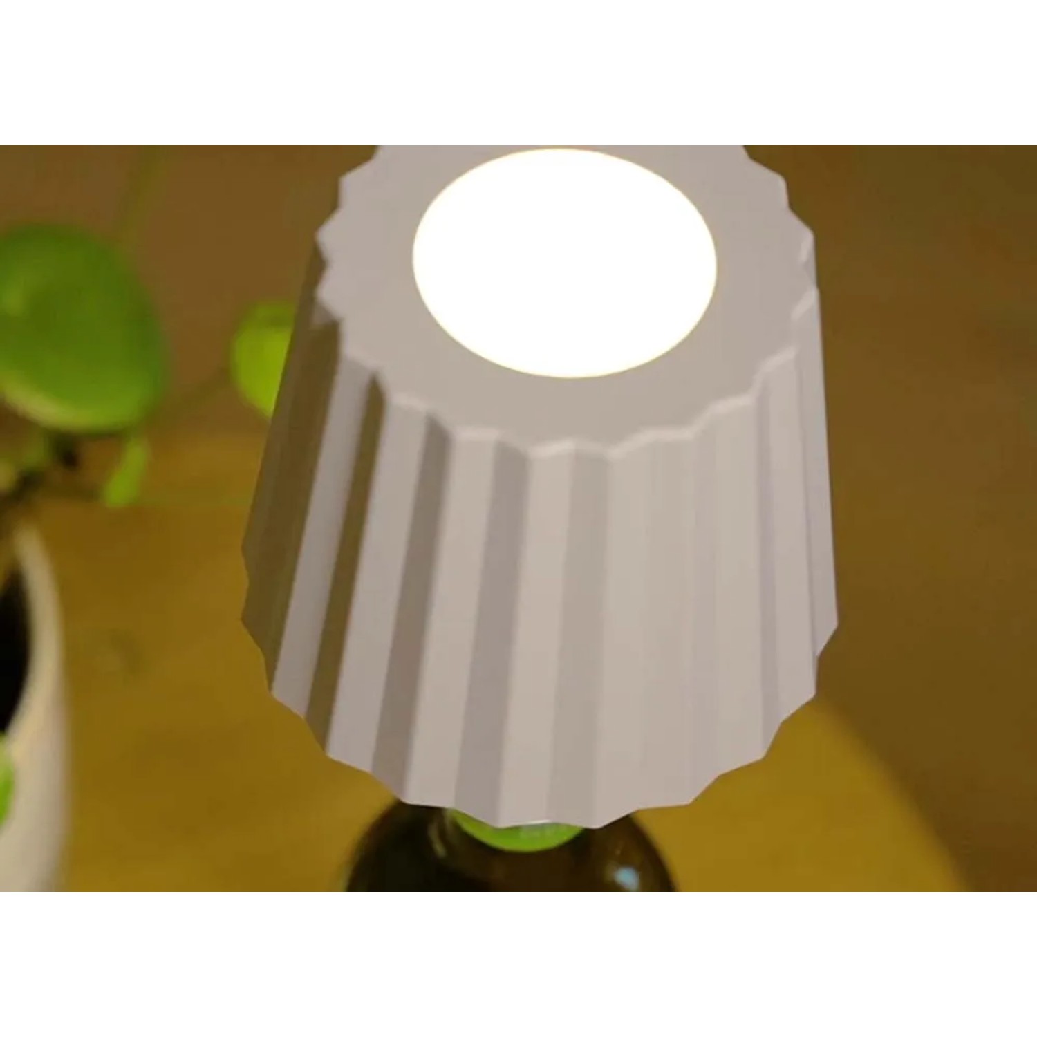 Luce decorativa da esterni t.b.t. a forma di cono, posizionata su una bottiglia.