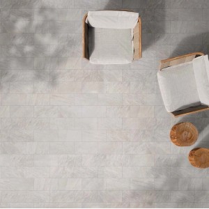 Piastrelle per pavimenti chiare t.b.t. con due poltrone e tavolini in legno.