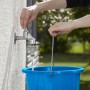 Rubinetto con raccordo per irrigazione riempie secchio blu.