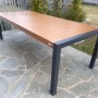 Tavolo da giardino rettangolare t.b.t. con effetto legno e struttura in metallo grigio.