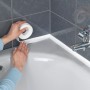 Applicazione del nastro sigillante bianco Wenko su una vasca da bagno.