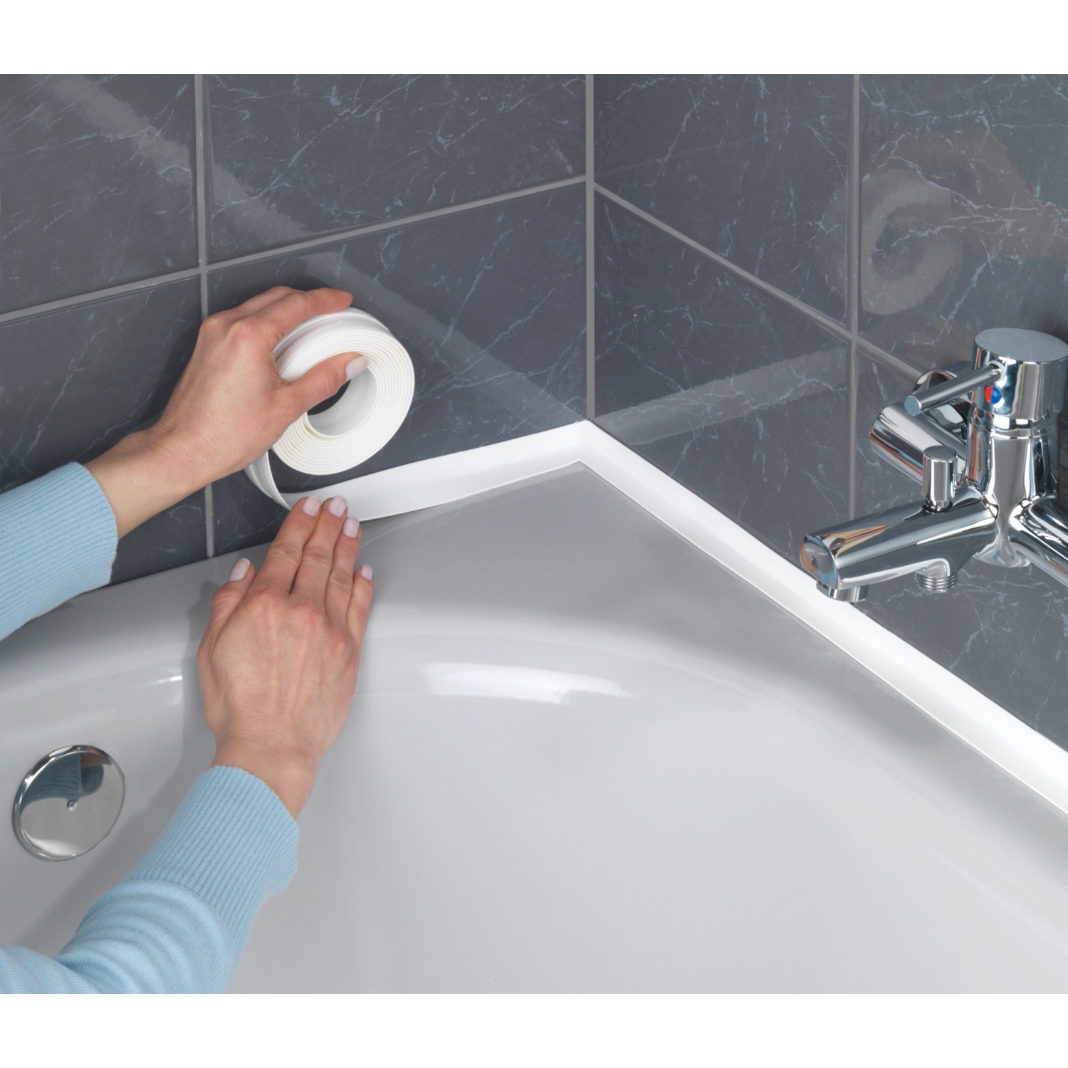 Applicazione del nastro sigillante bianco Wenko su una vasca da bagno.