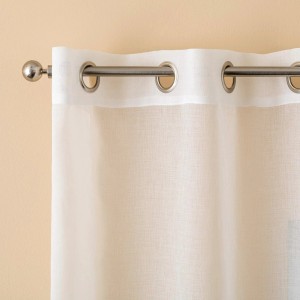 Tenda t.b.t. bianca e trasparente con occhielli appesa a un bastone.