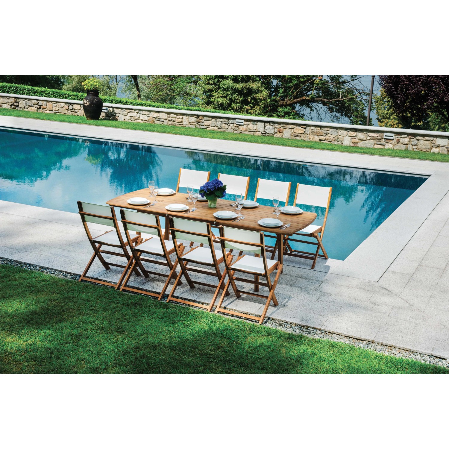 Tavolo da giardino t.b.t. apparecchiato con sedie a bordo piscina. Ideale per feste in giardino.