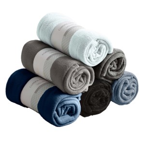 Coperte/plaid t.b.t. arrotolate e impilate in vari colori.