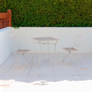Set di mobili da giardino beige con tavolo e due sedie per patio o balcone.