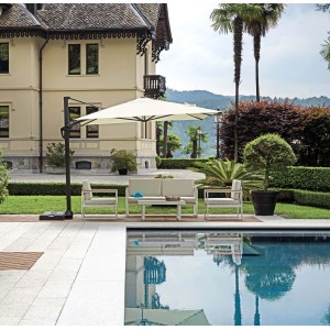 Ombrellone a braccio t.b.t. sopra set lounge a bordo piscina. Protezione solare in giardino.