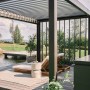 Pergola Biohort grigio scuro/argento metallizzato con tetto a lamelle e area lounge in giardino.