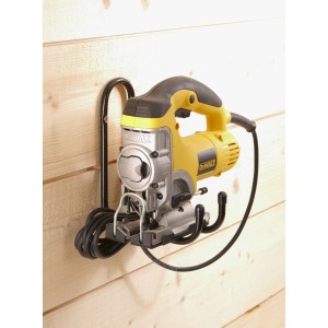 Seghetto alternativo giallo appeso a un gancio a muro nero su una parete di legno.