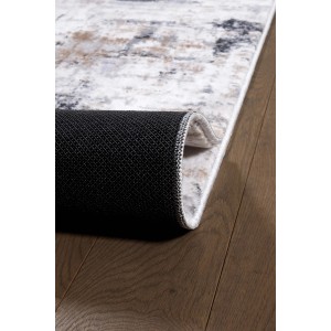 Dettaglio di un tappeto moderno (t.b.t.) con motivo astratto in grigio, bianco e beige.