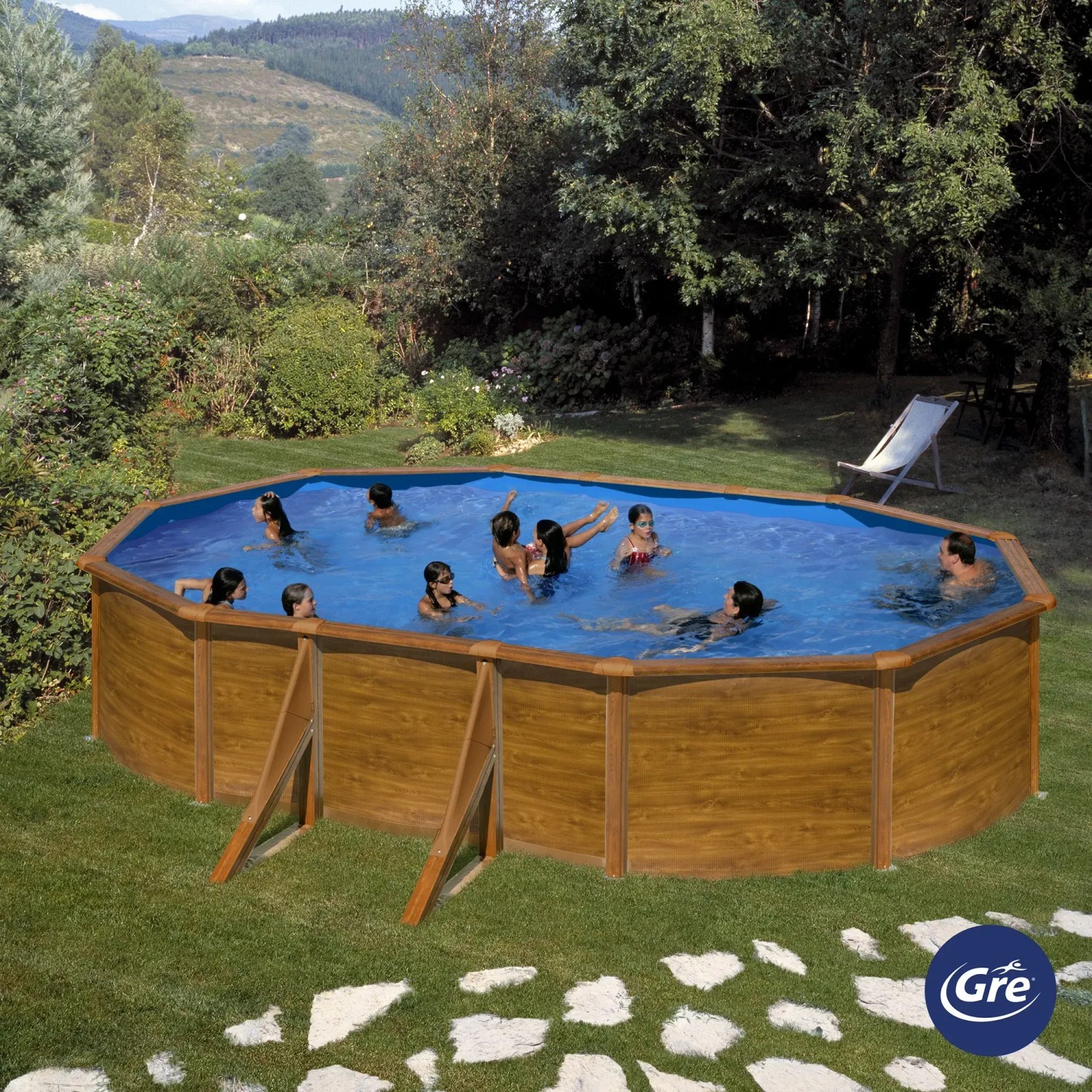 Piscina ovale Gre Pool Sicilia effetto legno, 500x300x120 cm, in giardino con persone che nuotano.