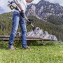 Uomo che lavora in giardino con decespugliatore a benzina Al-Ko BC 223 L-S con vista sulle montagne.