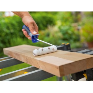 Rullo per vernice LUX 12cm in azione: rullo in nylon marrone per applicazione uniforme su legno.
