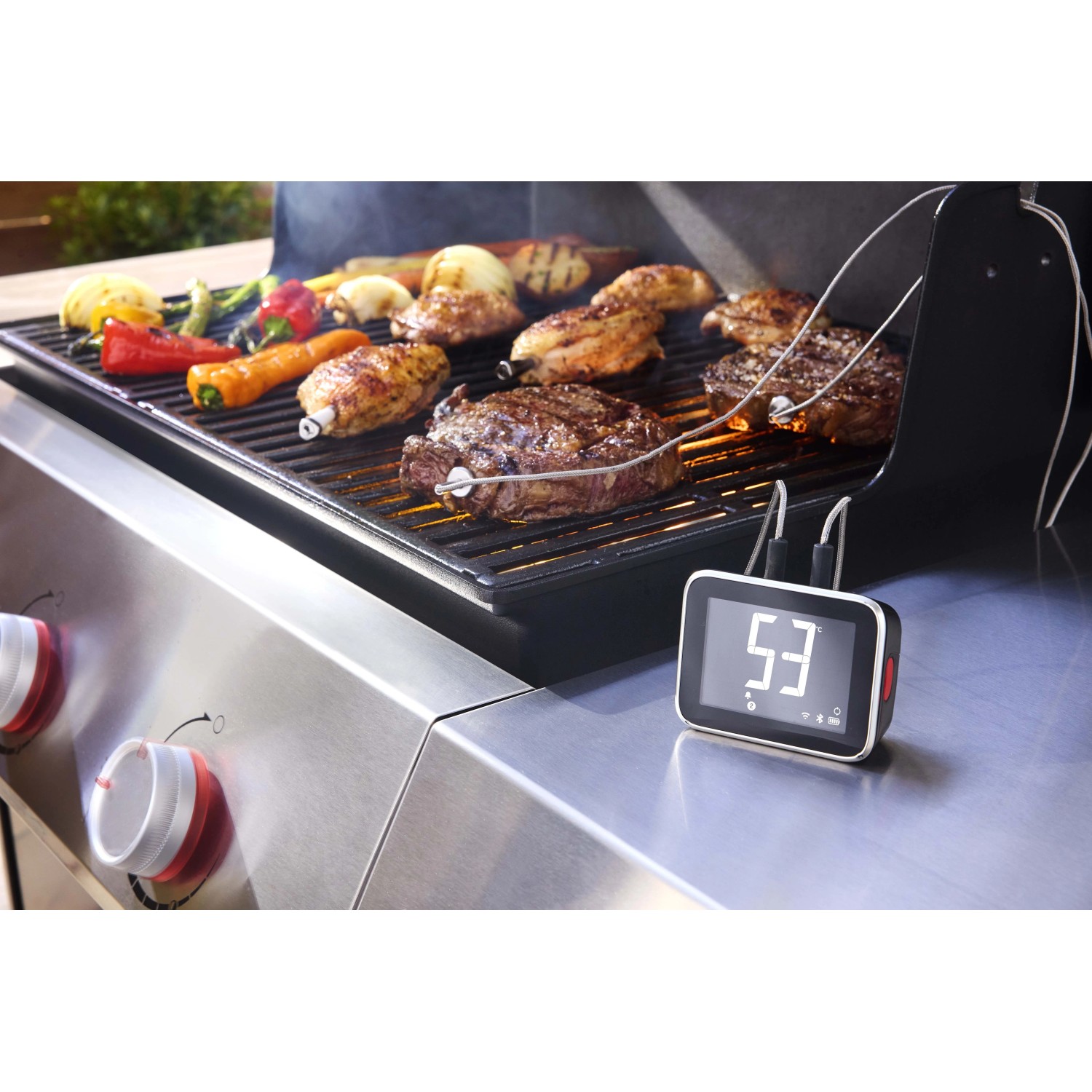 Weber Smart Hub display base station durante la grigliatura di carne e verdure.