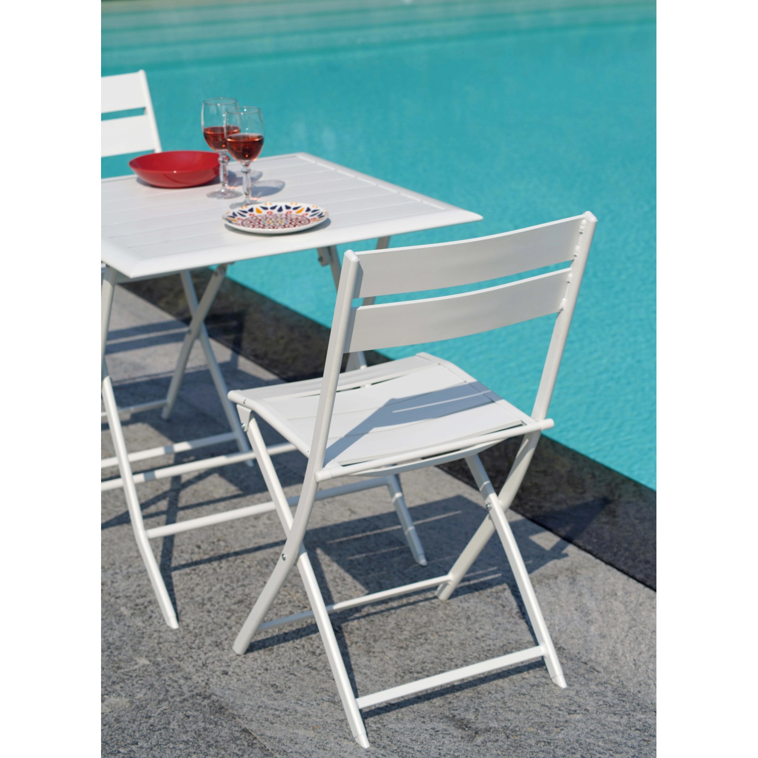Tavolo da giardino bianco con sedie a bordo piscina. Mobili da giardino pieghevoli.