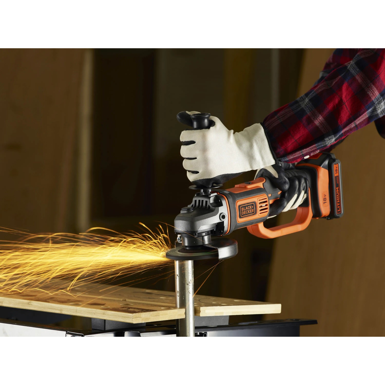 Smerigliatrice angolare a batteria Black+Decker BCG720N in azione, smerigliatura con scintille.