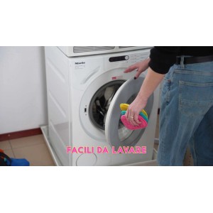 Persona che mette dei panni colorati per la pulizia in una lavatrice. Accessori per la pulizia.