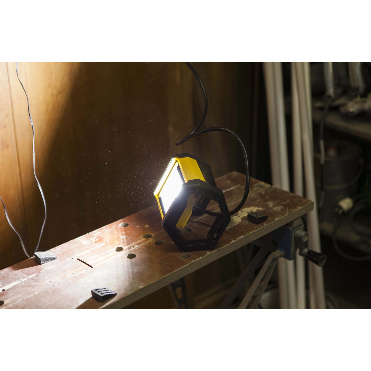 Faro LED da esterno t.b.t., giallo/nero, su un banco da lavoro.