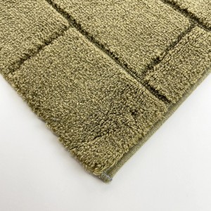 Dettaglio di un tappeto da bagno t.b.t. verde oliva con motivo quadrato.