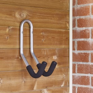 Gancio a muro in metallo con rivestimento nero per il fissaggio a una parete di legno.