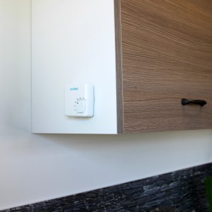 Cronotermostato t.b.t. montato su parete bianca.