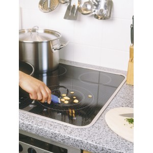 Raschietto universale LUX in uso per pulire residui di cibo da un piano cottura in vetroceramica.