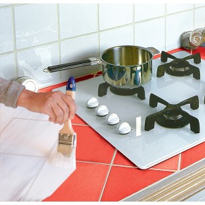 Piastrelle dipinte con primer isolante. Pennello e pentola sul fornello.