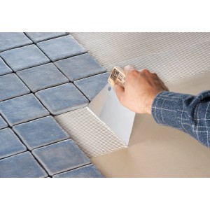 Spatola dentata LUX Classic che applica adesivo per piastrelle. Strumento per piastrellisti.