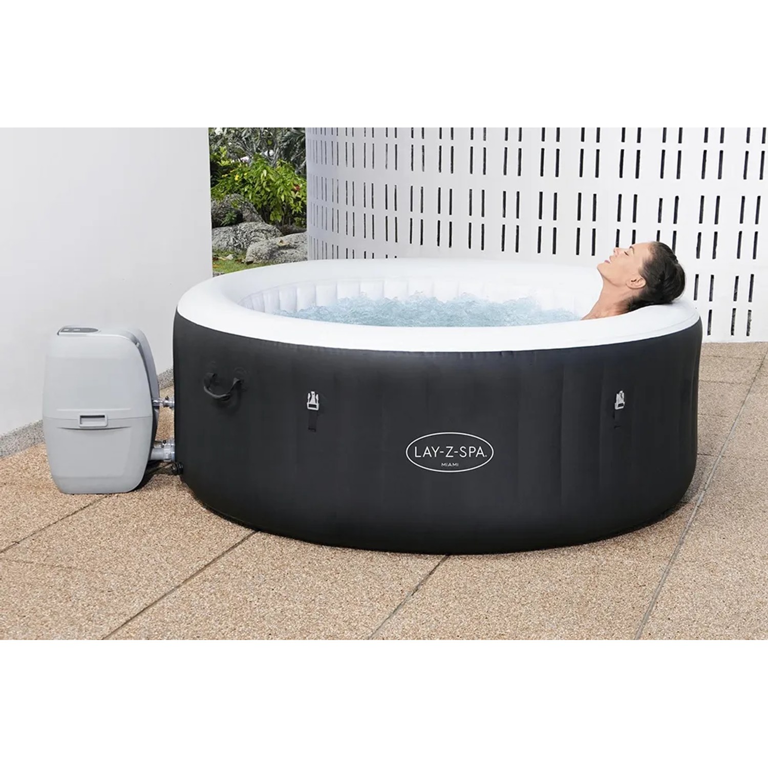 Bestway Lay-Z-Spa Miami AirJet: Vasca idromassaggio gonfiabile rotonda nera con pompa filtro e persona rilassante.